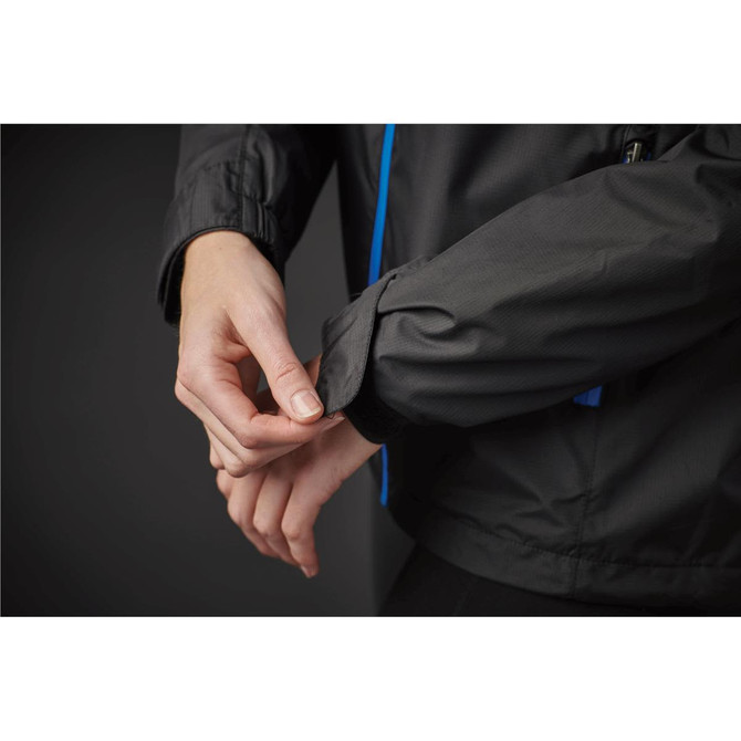 A black rain jacket featuring blue accents, focusing on a hand adjusting the cuff. It includes a logo.