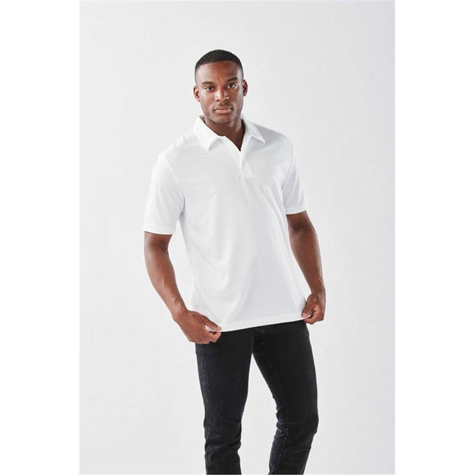 A man wearing a white polo shirt with a collar, standing against a plain background. The shirt has a logo.