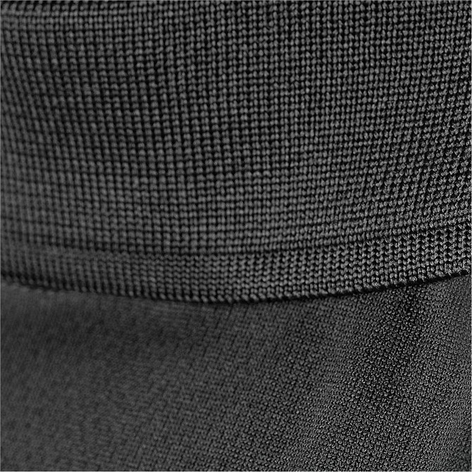 A close-up of a black polo shirt featuring textured fabric and a subtle hem detail.