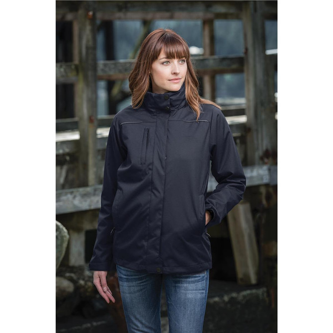 A woman wearing a black women's parka jacket, standing outdoors near a wooden structure.