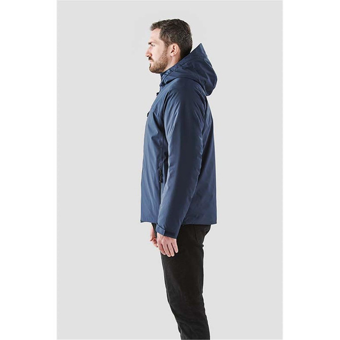 A man wearing a navy blue thermal shell jacket with a hood, viewed from the side. The jacket features a logo.