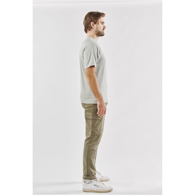 A light grey men's t-shirt displayed on a model standing side-on, paired with olive green trousers. The shirt has a logo.