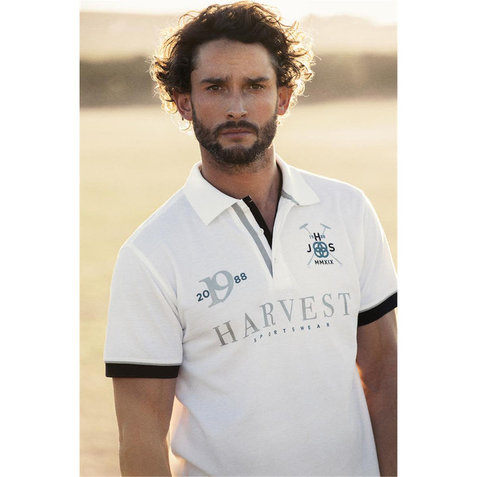 A white polo shirt with black detailing and a logo, featuring short sleeves and a collar.