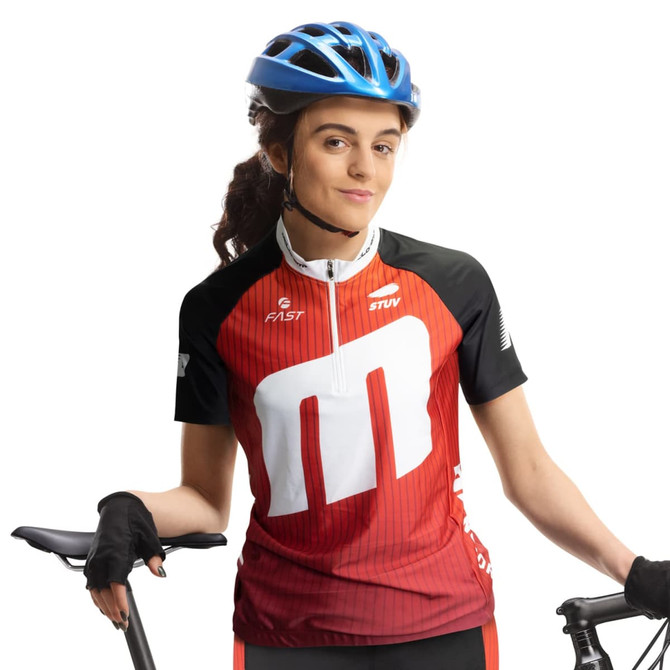 A woman in a red and black cycling jersey with a logo, wearing a blue helmet and holding a bike.