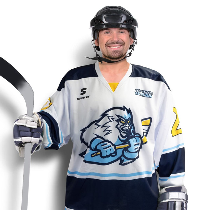 A hockey jersey featuring navy and white colours with a graphic design, worn by a player holding a hockey stick.