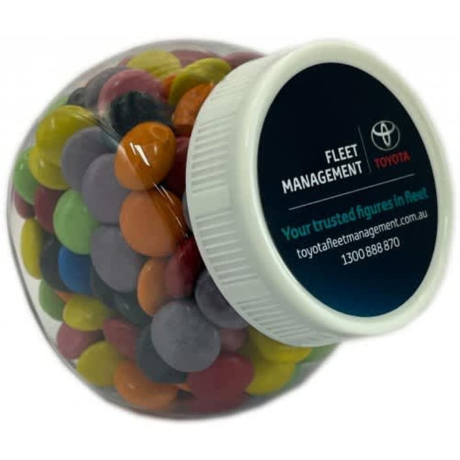 A plastic jar filled with colourful choc beans, featuring a lid and a logo.
