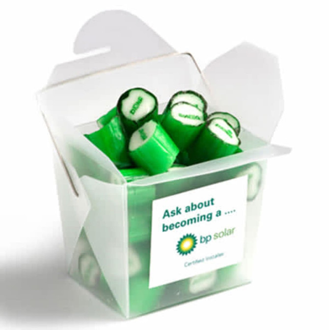 A frosted noodle box containing green personalised rock candy pieces. The box has a logo on it.