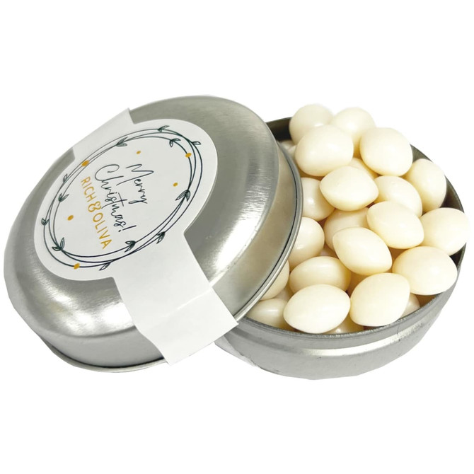 A silver tin filled with white chewy mints, featuring a decorative label on the lid.