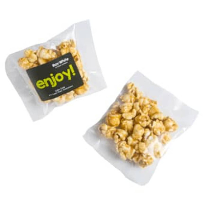 A bag of caramel popcorn featuring golden kernels in a clear wrapper with a logo.