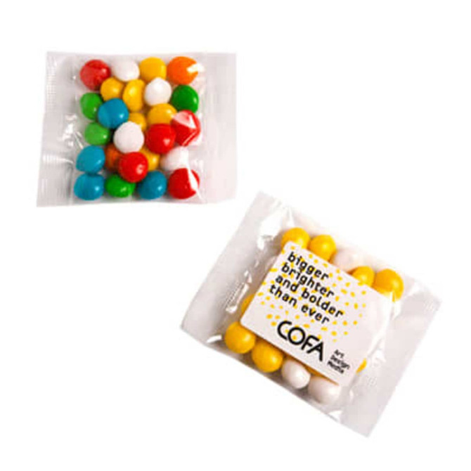 A packet of chewy fruit sweets in vibrant colours, including red, yellow, green, blue, and white, with a logo.