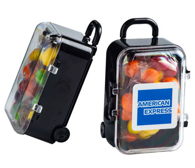 A black carry-on case containing colourful Skittles, featuring a logo on the front. 