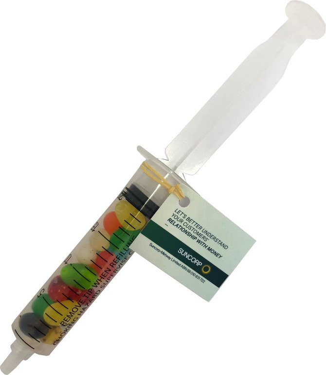 A syringe filled with multicoloured JELLY BELLY jelly beans, featuring a clear barrel and a plastic plunger.