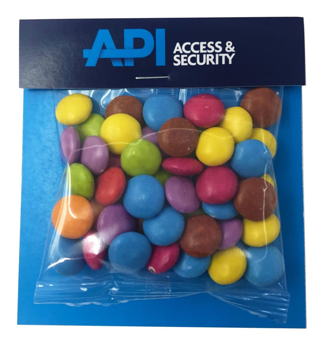 A clear bag filled with colourful Smarties in various shades, featuring a branded header.