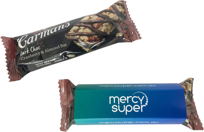 A muesli bar featuring dark chocolate, cranberry, and almond, with a branded sleeve in blue and green.