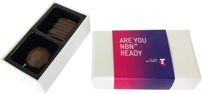 A white box containing two chocolate treats, one with a smooth surface and the other with ridges, featuring a logo.