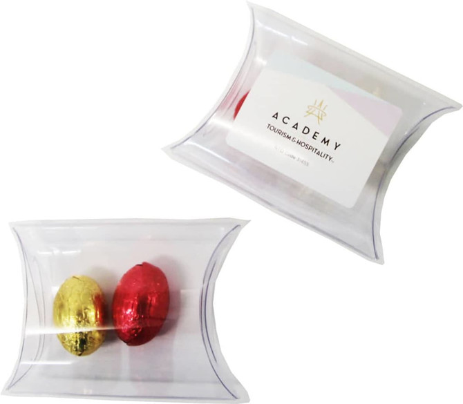A clear pillow pack containing two mini solid Easter eggs in gold and red. It features a logo on the packaging.