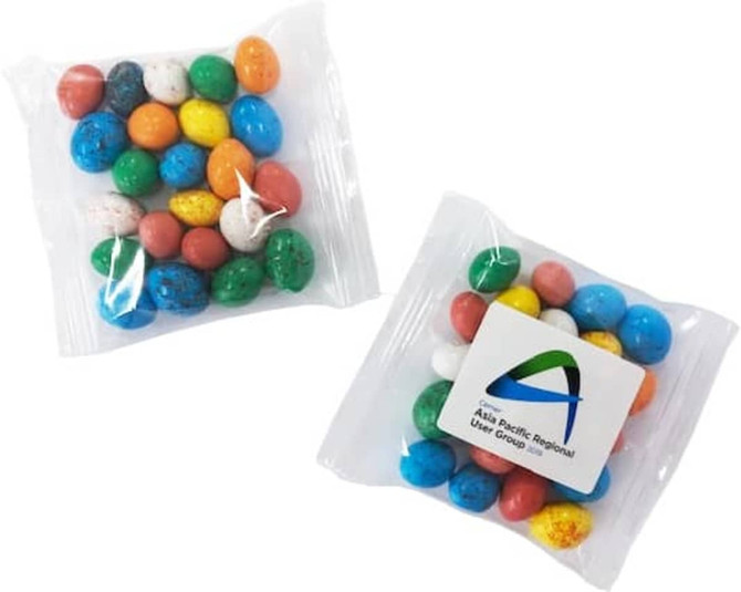 Candy coated chocolate eggs in a clear bag, featuring various colours including blue, green, orange, and white.