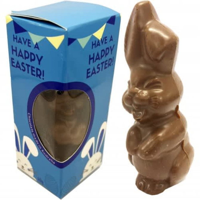 A chocolate Easter bunny in a light blue box with a window, featuring a festive header card.