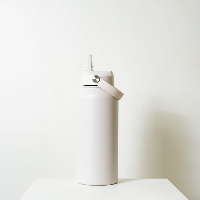 A drink bottle in a soft white finish with a screw-top lid and a handle, featuring a simple logo.