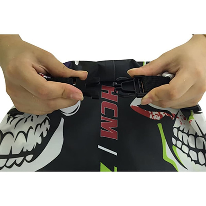 A dry bag featuring vibrant colours and a PVC window, being secured by hands with adjustable straps.