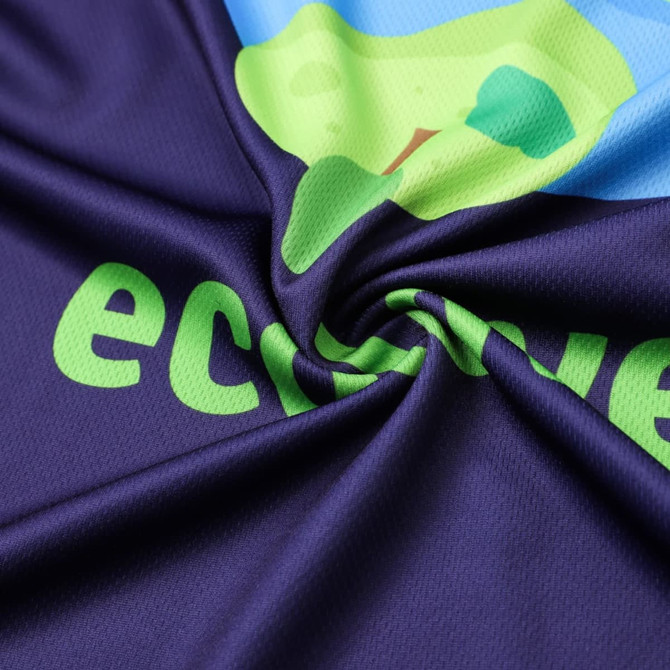 A close-up of a V-collar T-shirt in navy with a colourful design and a logo. The fabric is soft and textured.