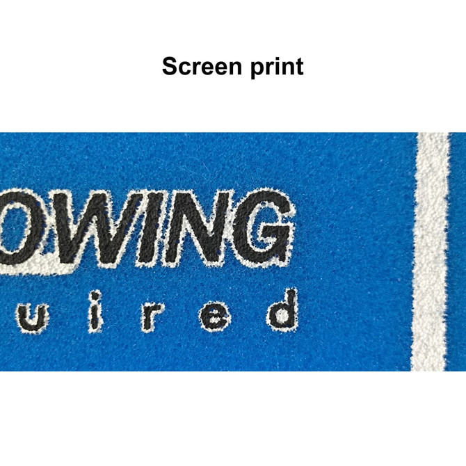 A close-up of a blue fabric showcasing screen print detailing, including black and white text elements.