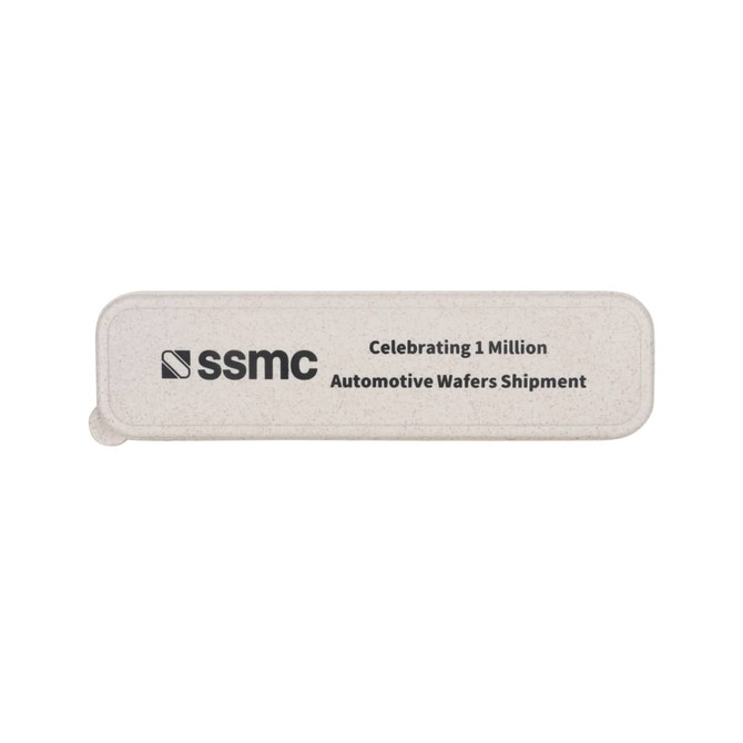 A rectangular, light grey eco-friendly token with a logo and text celebrating automotive wafer shipments.
