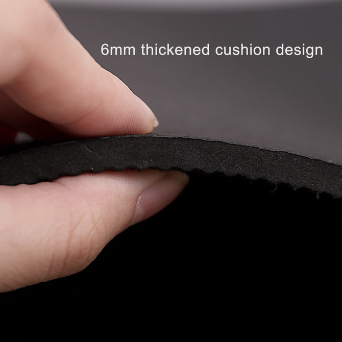 A hand holding the edge of a black yoga mat, highlighting its 6mm thick cushion design.