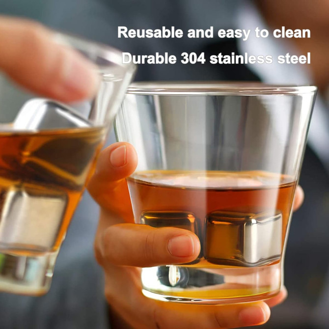 A set of four stainless steel ice cubes in a glass of amber liquid, with another glass held in a hand nearby.