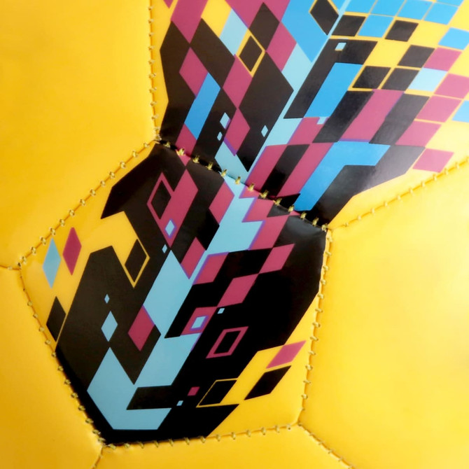 A yellow soccer ball featuring a vibrant geometric pattern in blue, pink, and black, with a logo present.