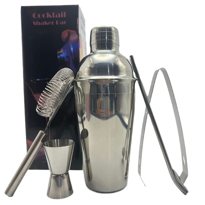 A drink bottle with a shiny silver cocktail shaker, strainer, jigger, tongs, and packaging in the background.