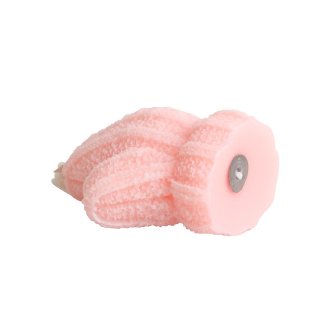A pink glove-shaped candle with textured detailing and a metal base.