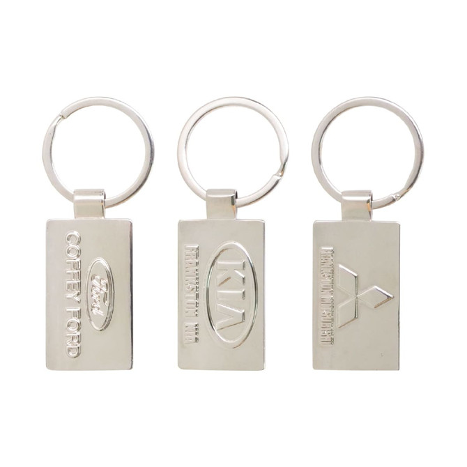 A trio of silver custom-shaped die struck keyrings with various logos and designs.