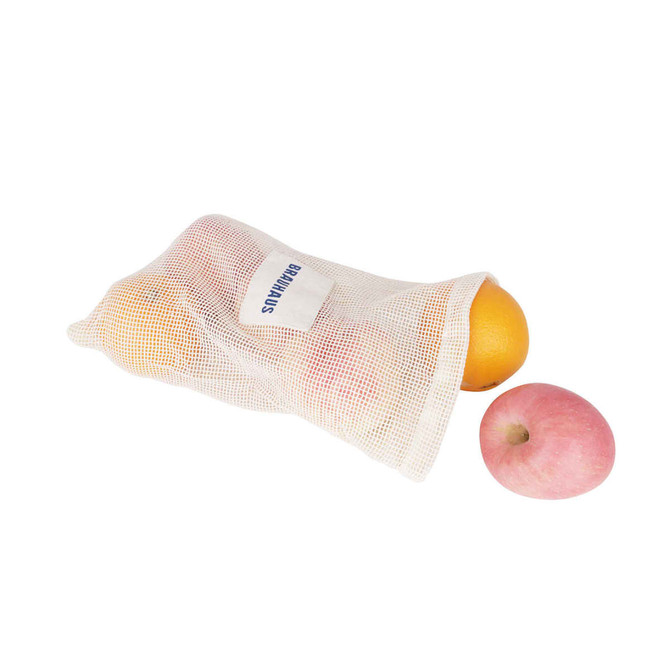 A cream-coloured organic cotton mesh bag containing oranges and a pink apple, with a logo visible.