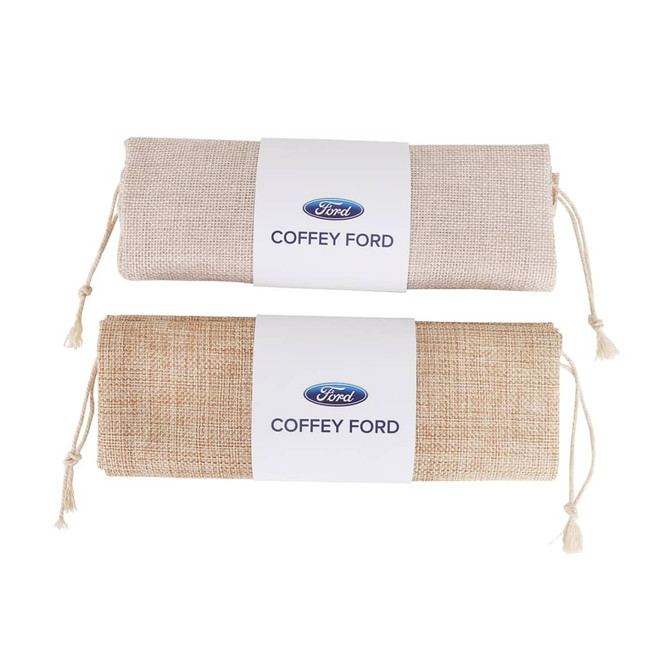 A small jute produce bag in natural and light brown colours, featuring a logo on a white label.