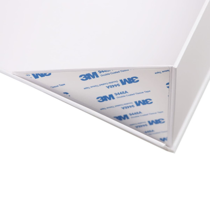 A small foldable white magnetic box with a ribbon and a 3M double-sided tape at the corner.