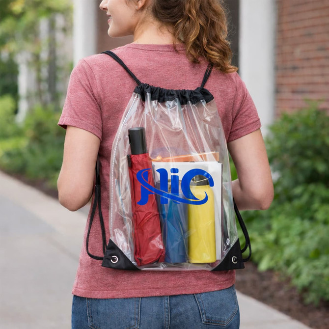 A clear PVC drawstring bag worn as a backpack, containing a red umbrella and colourful drink bottles.