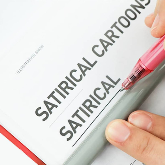 A writing pen with a pink barrel and a transparent grip, resting on a page with bold text. The pen has a logo.