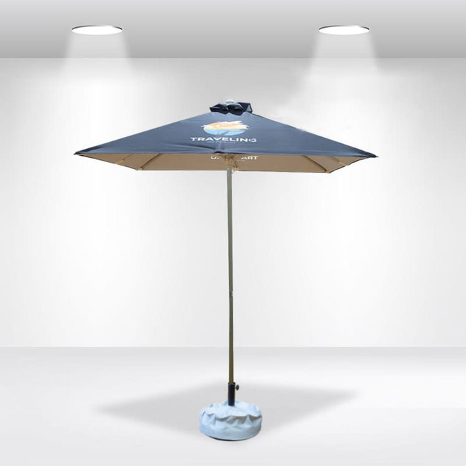 A square patio umbrella with a blue canopy and a light blue base, featuring a logo on the top.