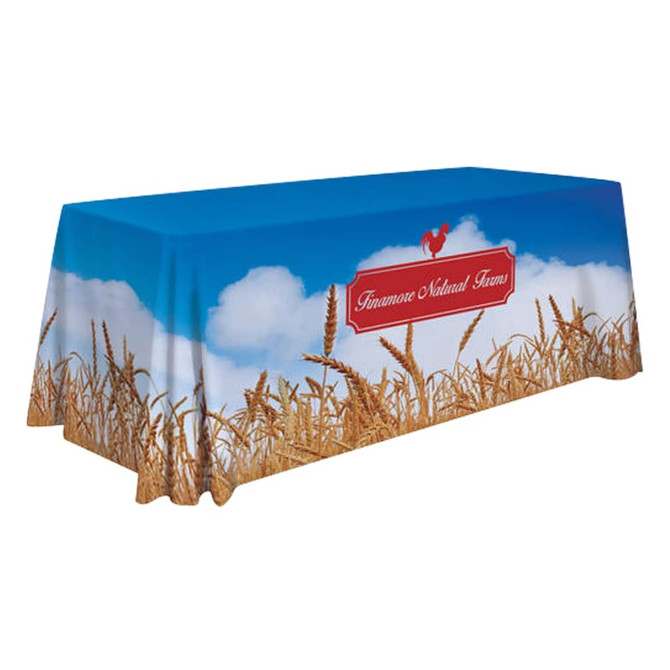 A 6ft rectangular tablecloth featuring a blue sky and wheat field design, with a logo on one side.