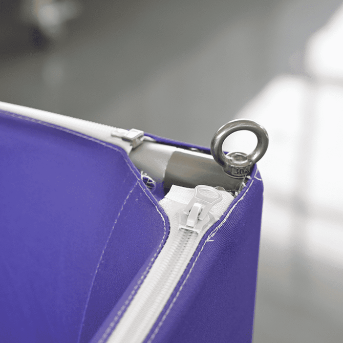 A purple hanging banner featuring a zipper and a metallic ring for attachment.