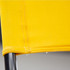A close-up of a bright yellow fabric detail attached to a black metal frame, showcasing stitching and texture.