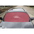 A red car shade covers the windshield of a parked vehicle, featuring a logo in the centre.