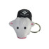 A cow-shaped stress reliever keyring in white, black, and pink, featuring a logo on top.
