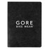 A black notebook with a textured cover featuring a logo. It has a smooth finish and blank pages inside.