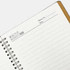 A spiral notebook with a white paper interior and a brown cover, featuring metal spiral binding.