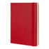 A large red Moleskine classic hard cover notebook with an elastic closure and blank pages.