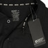A black unisex polo shirt with care instructions and a tag, featuring a logo.