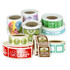 Rolls of printed stickers in various designs and colours, including some with logos and branding.