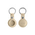 A beige PU leather AirTag holder with a keyring, featuring a circular design and a small metal snap button.